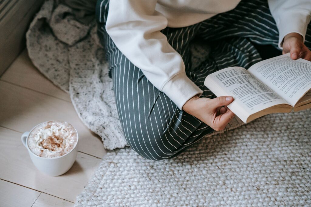 Woman reading on floor in blankets.