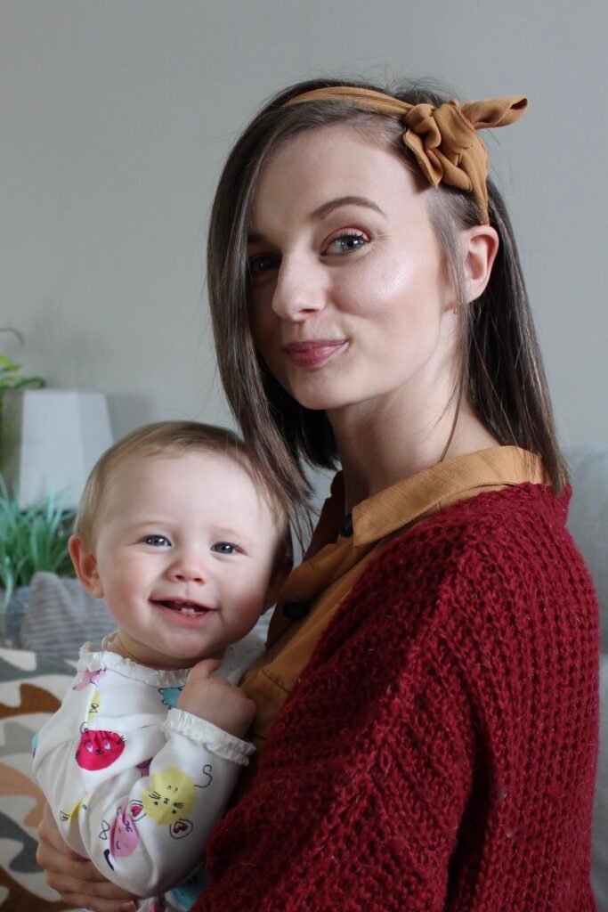 Woman holding a nine month old baby. This is to go with an personal article discussing how I have changed during motherhood, nine months in.