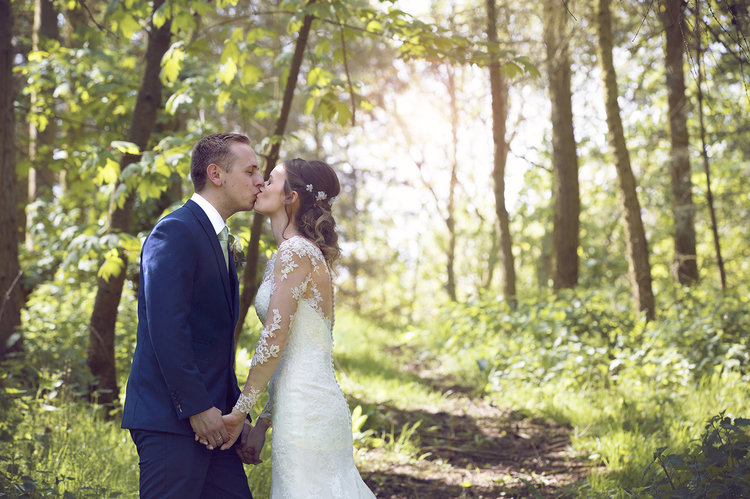 5 Things I'd do differently on my wedding day. Bride and groom kissing in woodland spot.