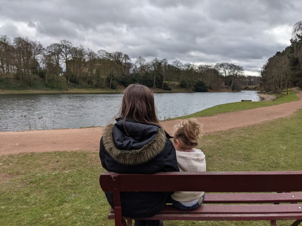 Claire sat with her daughter, looking out onto a lake at Nostell, using their National Trust pass. Our National Trust pass has 100% been one of our simple joys in March.