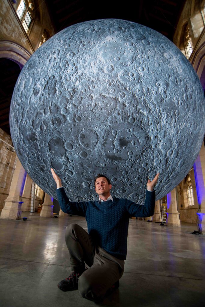 Luke Jerram holding up thhe Moon.