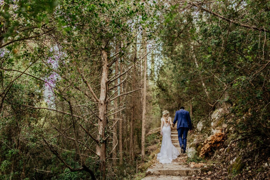 Wedding day couple walking through the woods.