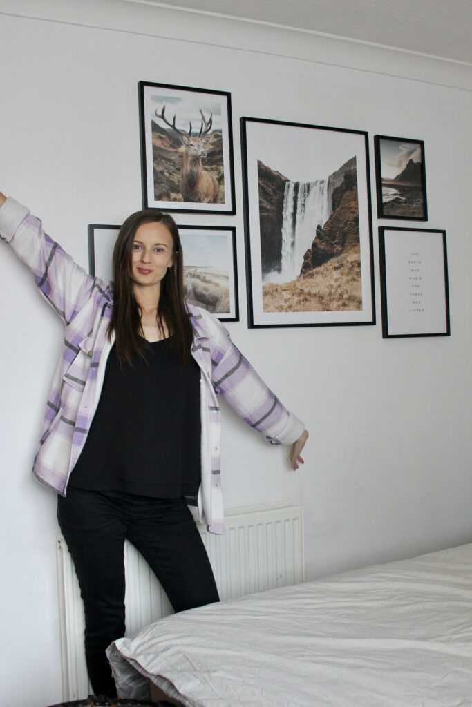 Claire Mac stood in front of gallery picture wall.