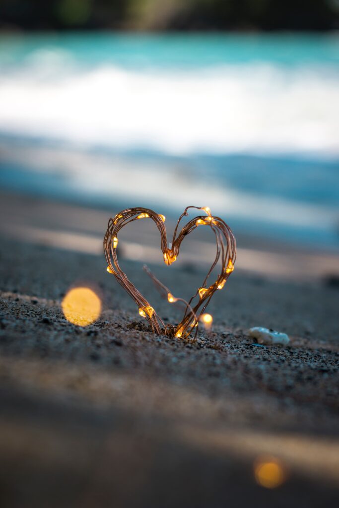 Heart shaped fairy lights in the sand.