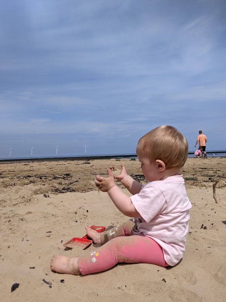 Small child playing in the sand at the beach.