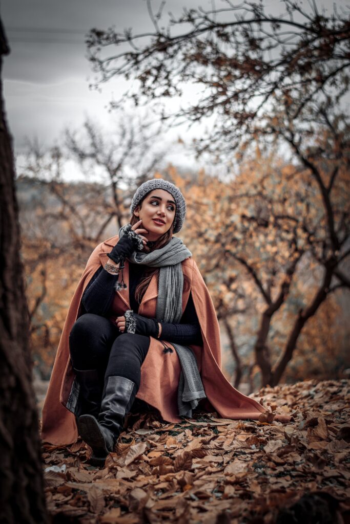 Lady wearing camel coat in the autumn leaves.