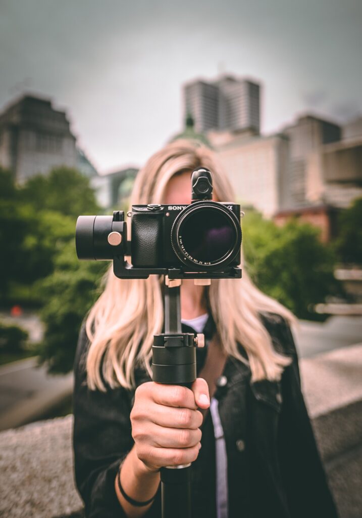 Woman holding up video recorder.