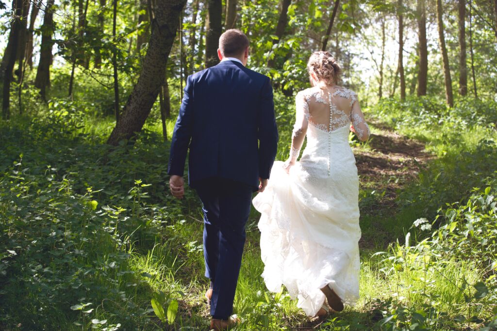 Husband and wife walking away into the woodlands.