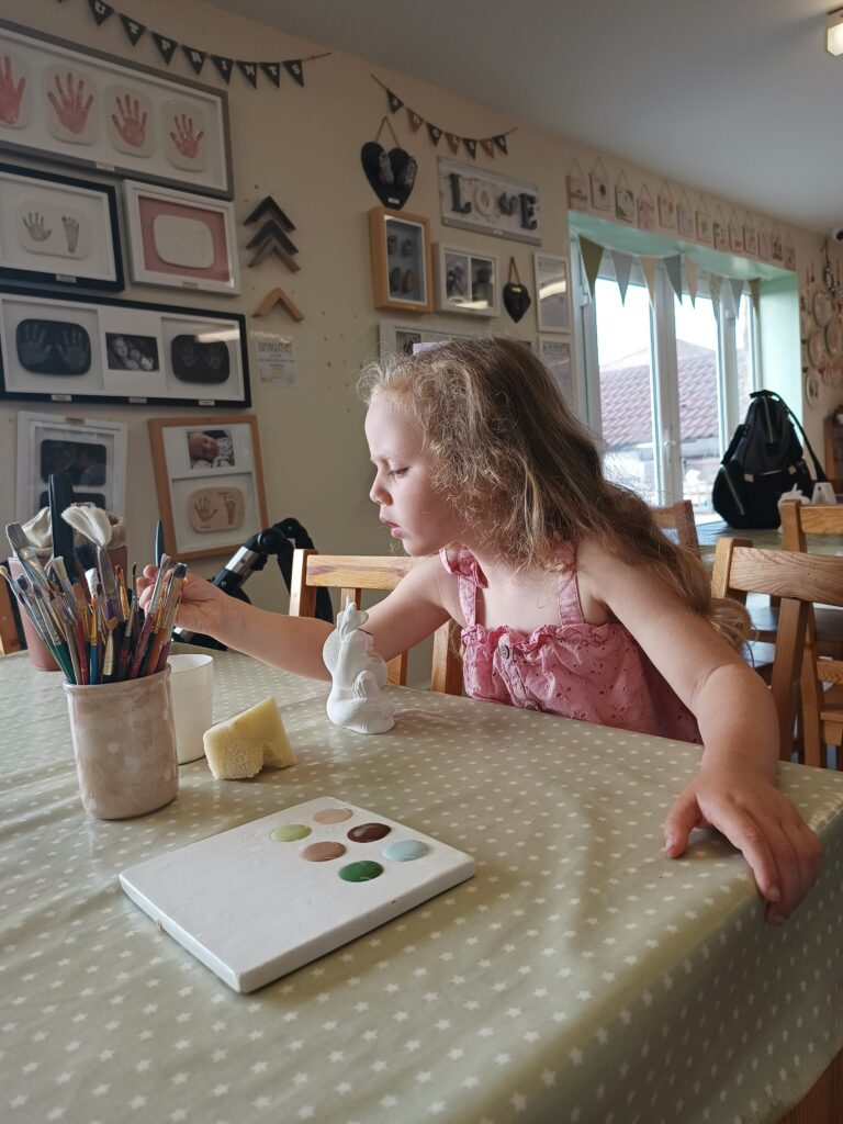 Little girl pottery painting.