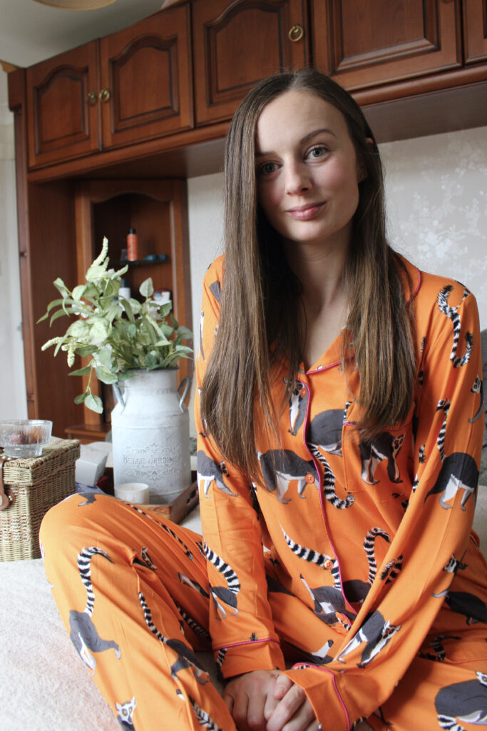 Claire Mac wearing orange lemur printed Chelsea Peers pyjamas.