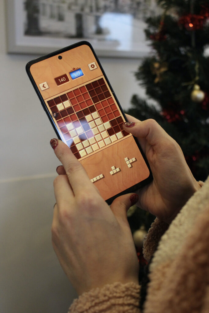 Claire Mac playing game on smart phone.