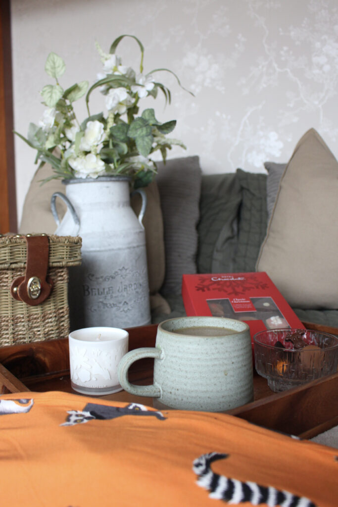 Lifestyle shot of coffee amongst Chelsea Peers pyjamas and Hotel Chocolat chocolates.