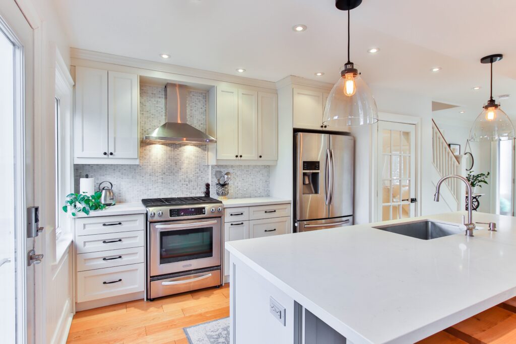 Make your kitchen inclusive with these four pointers. Image shows white shaker style kitchen with black hardware and lighting.