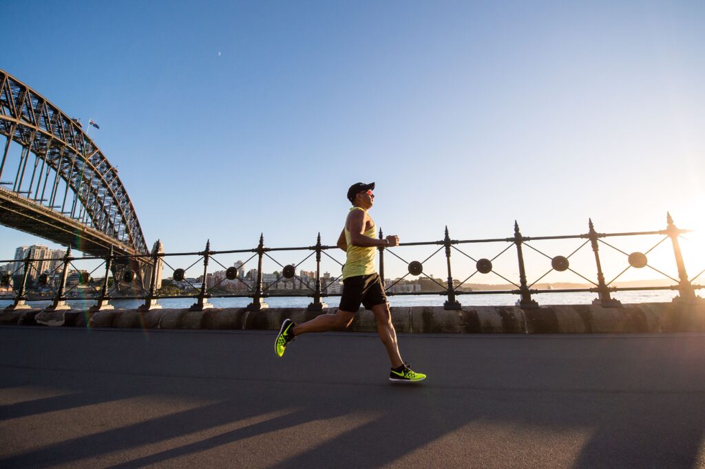 Running and strength training. Man running along bridge.