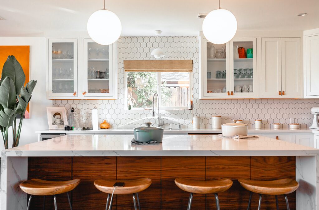 Image of a kitchen with geometric pring tiles. White wood doors and dark wood cabinets.