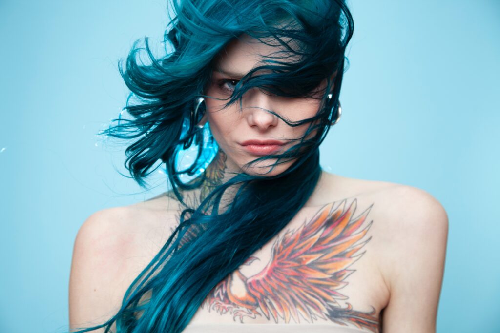 Woman with electric blue mullet style hair.