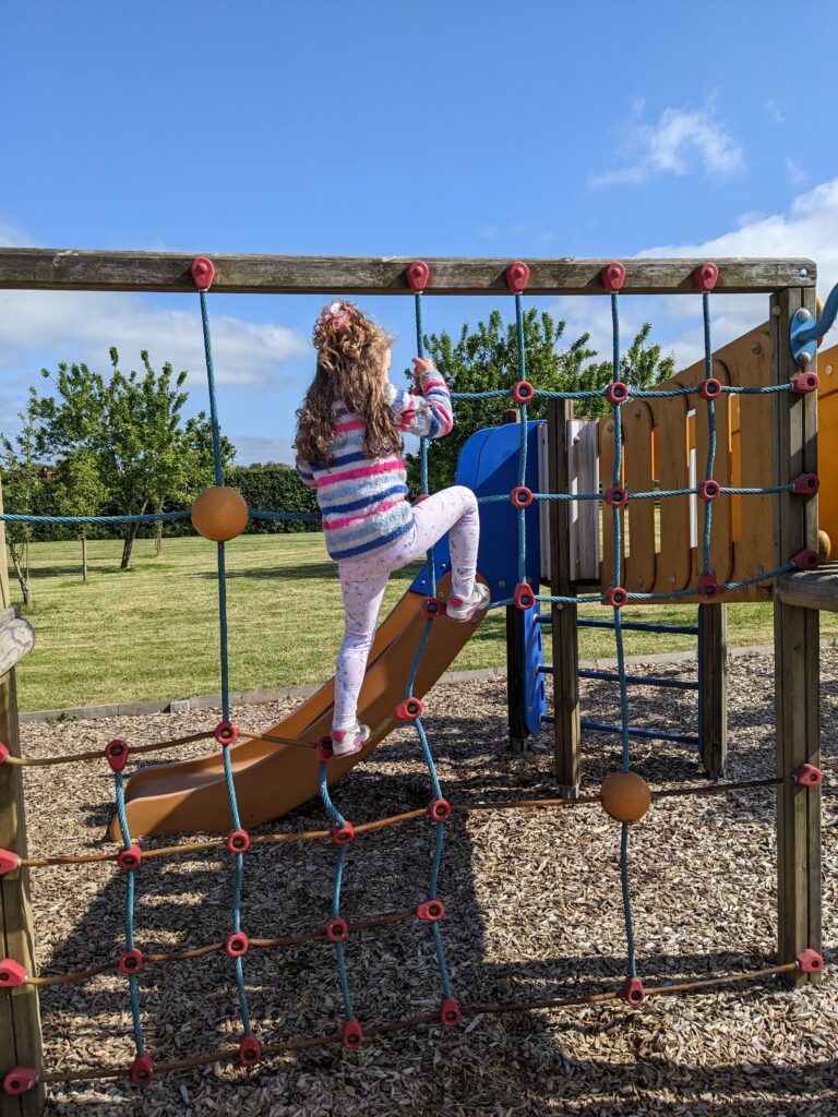 Young girl climbing climbing frame at Barker Stakes Farm.