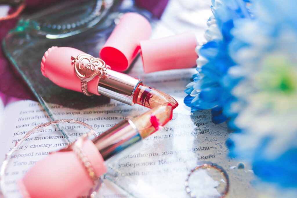 Summer themed beauty flat lay featuring pink lipsticks.