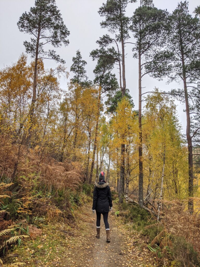 Claire Mac walking away from camera in woodland scene at Corrieshalloch Gorge in Scotland whilst doing the North Coast 500.