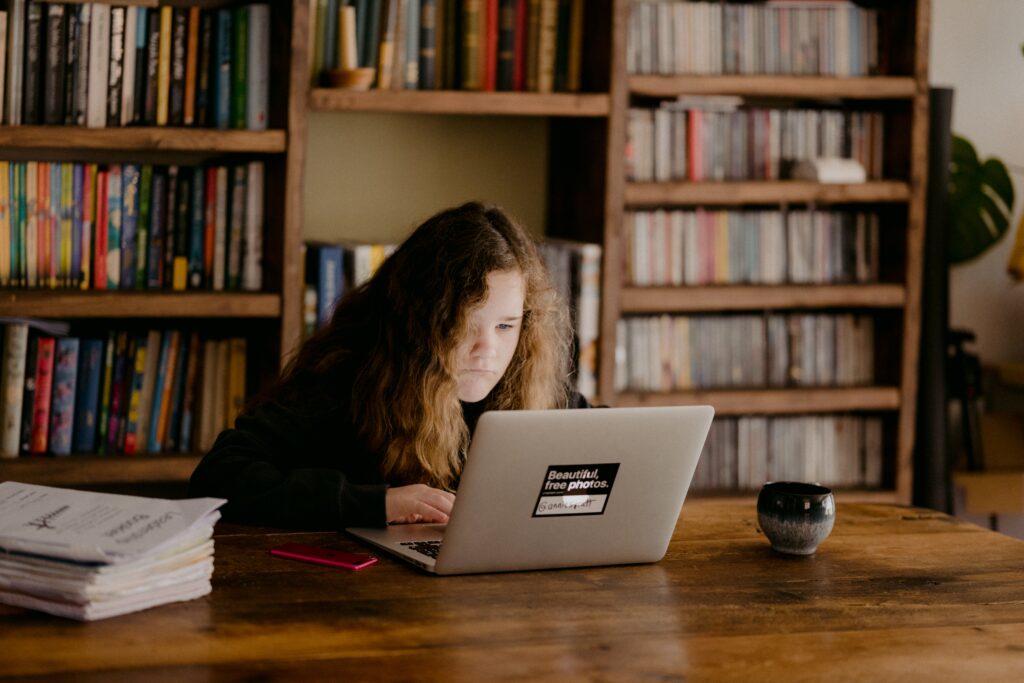 Positive learning environment for a teenage girl sat at laptop.