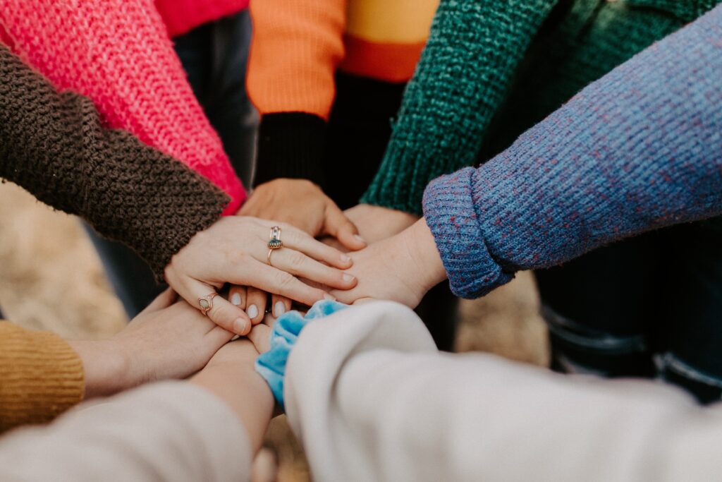 Hands in the centre of image showing community spirit and community involvement.