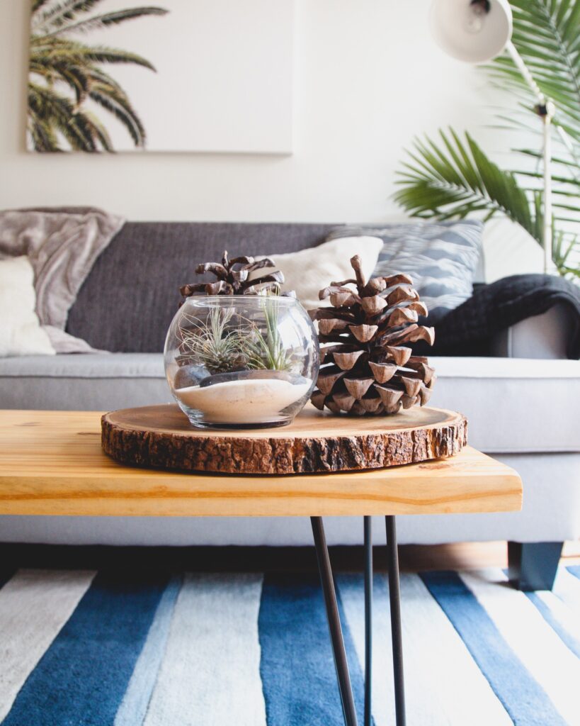 Coffee table set up with blue rug and grey sofa.