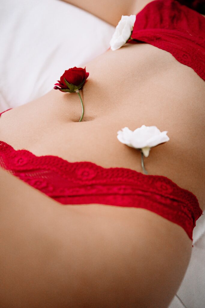 Lady in red lingerie with red and white roses across stomach for an article about intimate area health.