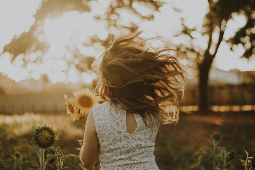 Sunflower shot of girl running away into the distance. This is for a blog post discussing strategies to prepare your child for the best future.