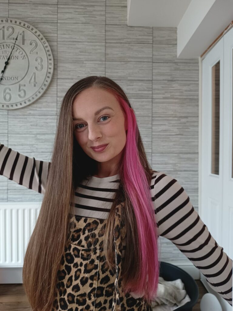 Claire Mac with bright pink stripe in hair.