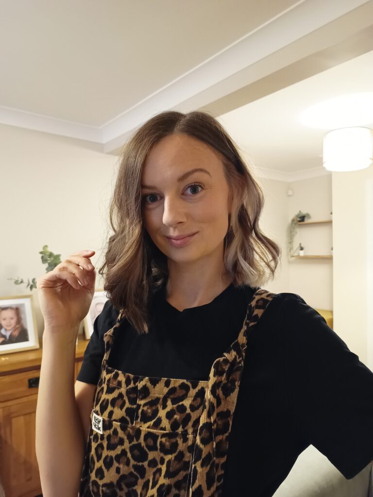 Claire Mac wearing leopard print dungarees with short bobbed hair.