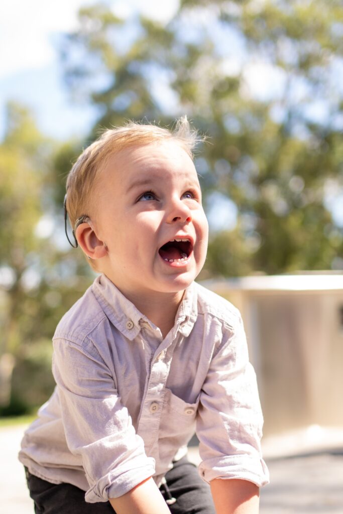 Young boy wearing cochlear implant. This is to go with an article that identifies hearing problems in children.
