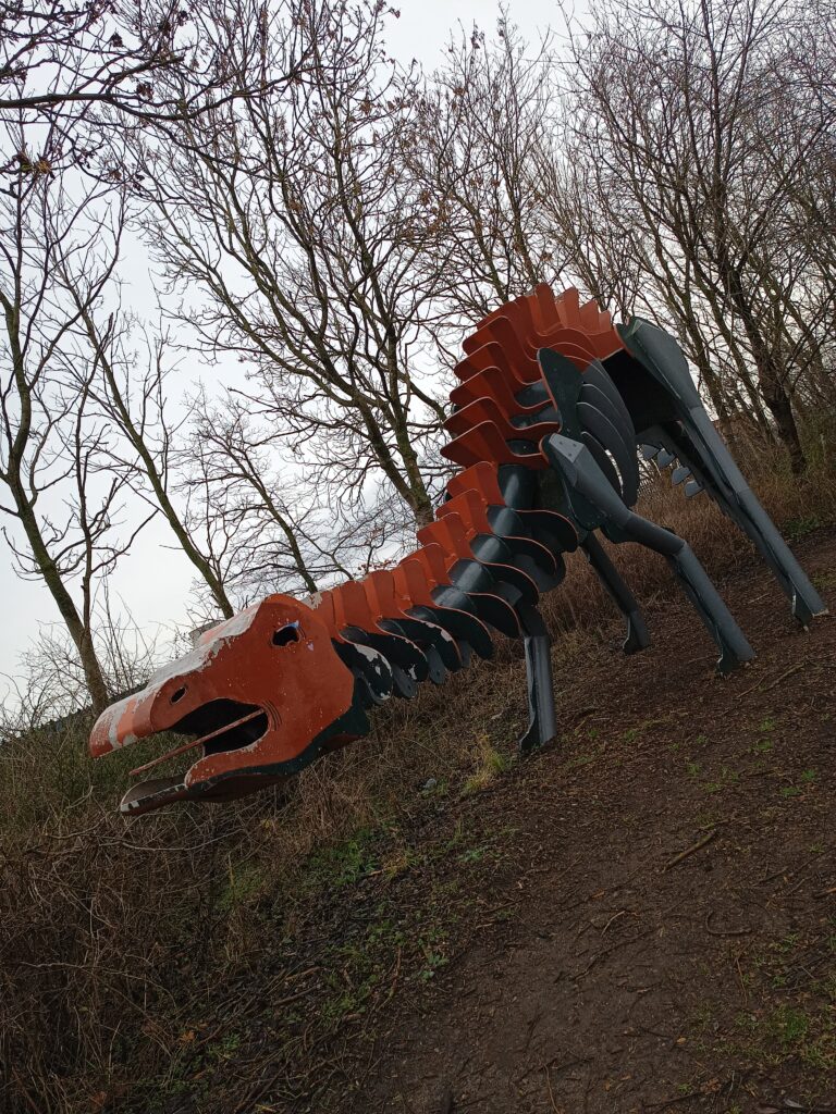 Steel sculpture of a brontosaurous.