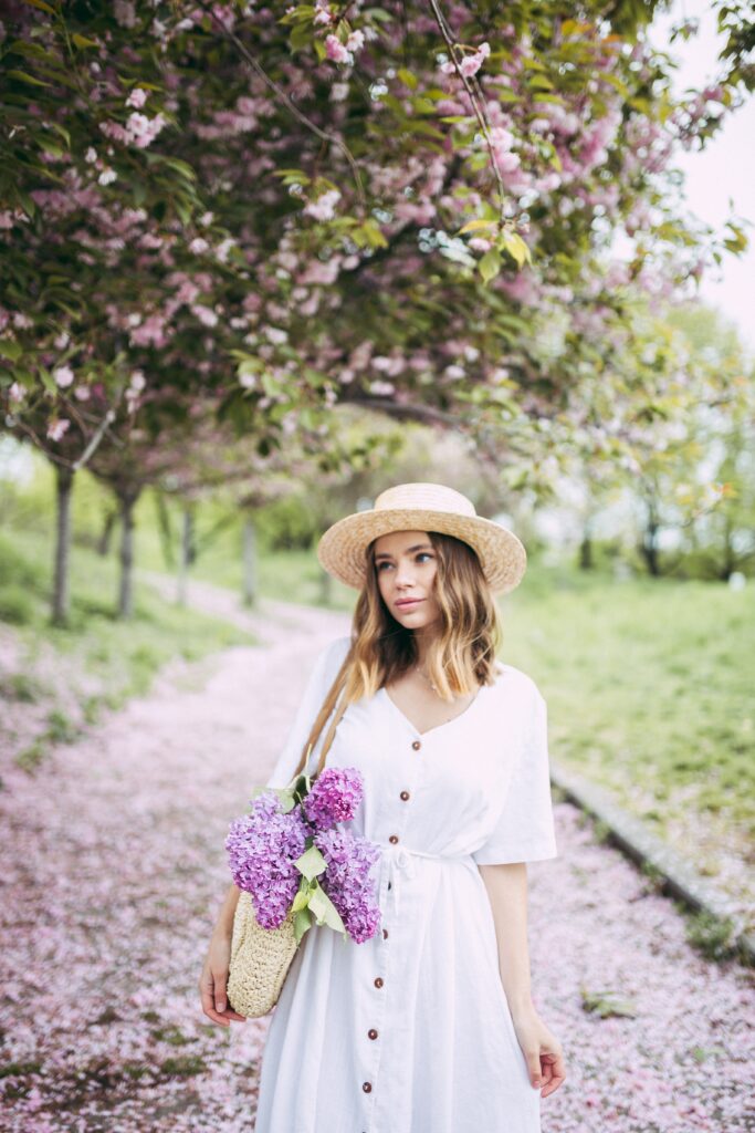 Woman in white dress walking through park.