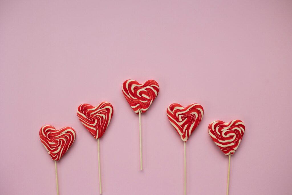 Red love heart shaped lollipops for a blog post about spreading love through random acts of Valentine's.
