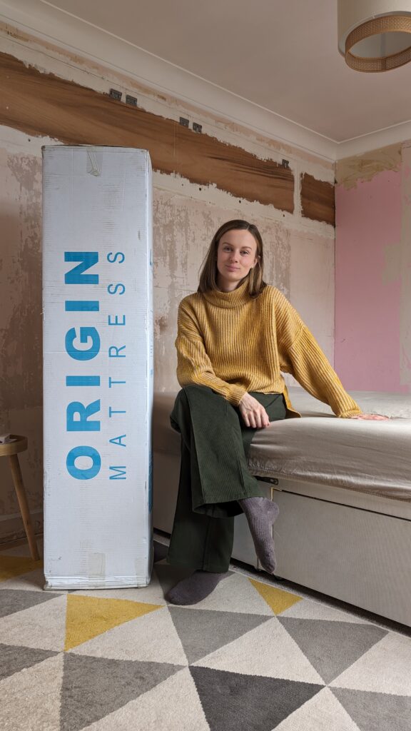 Claire sat next to a boxed mattress.