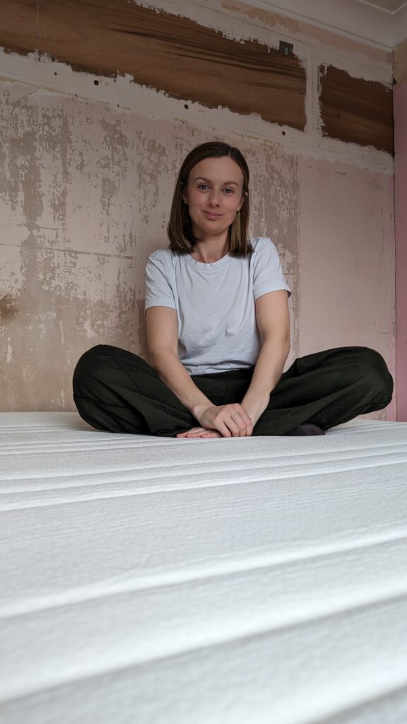Claire Mac sat on mattress.