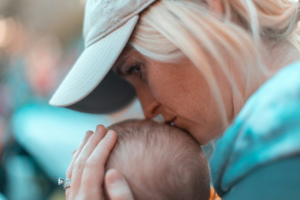 Woman kissing head of a baby. This is to go with an article discussing how to support your children during divorce.