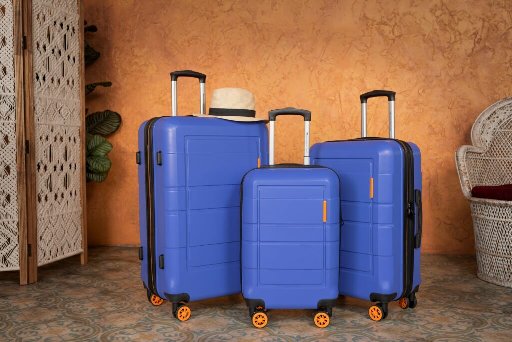 Image of three blue and orange suitcases. This is to go with an article explaining if replacing the wheels on a suitcase impacts its performance.