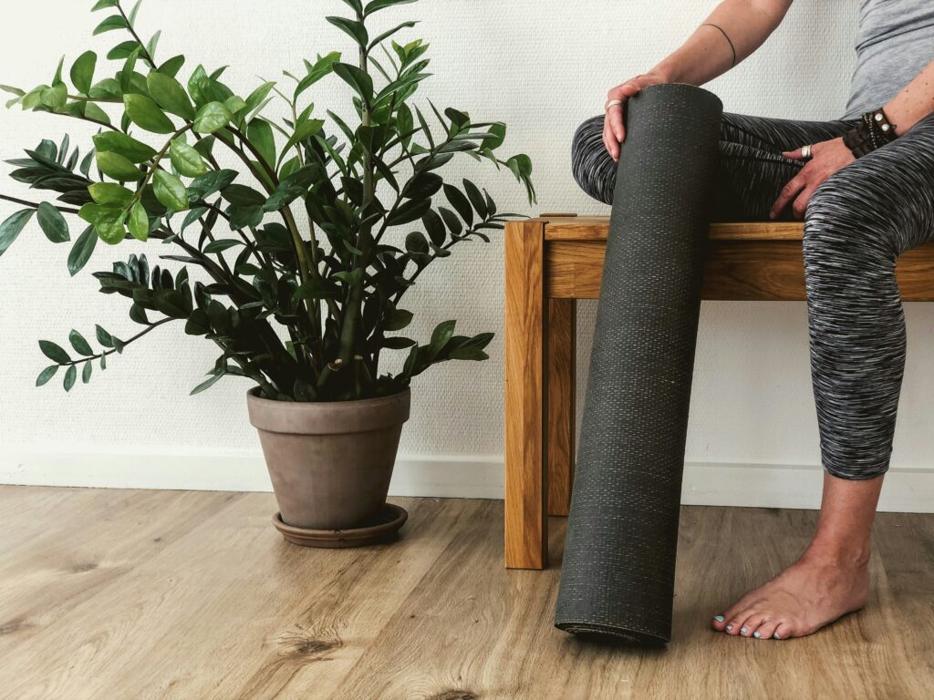 Woman sat on bench with a yoga mat - This article gives different hobbies for body and mind wellness.