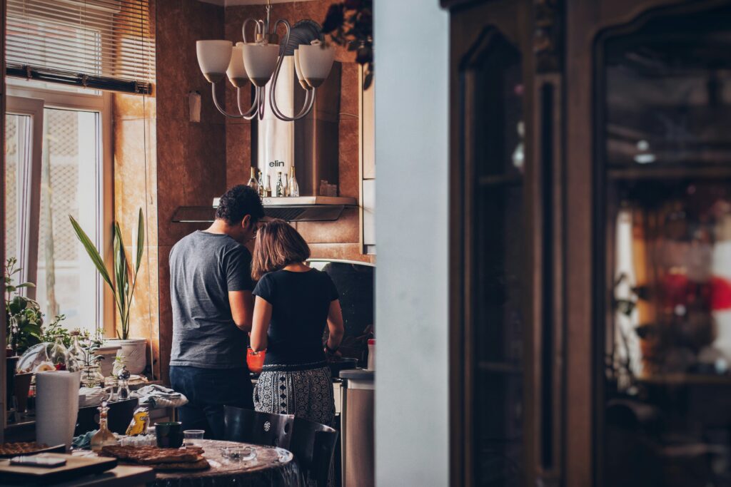 Couple in a kitchen with backs towards the camera. This is to go with an article giving average time frames for the house moving provess.