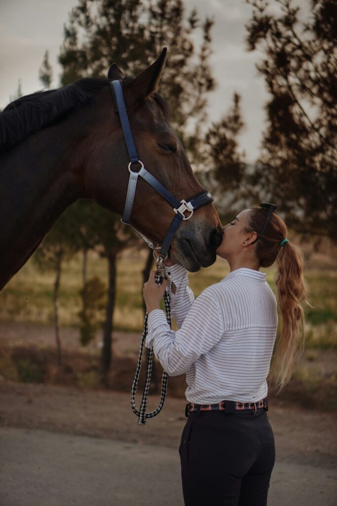 Woman wearing equestrian fashion with horse.