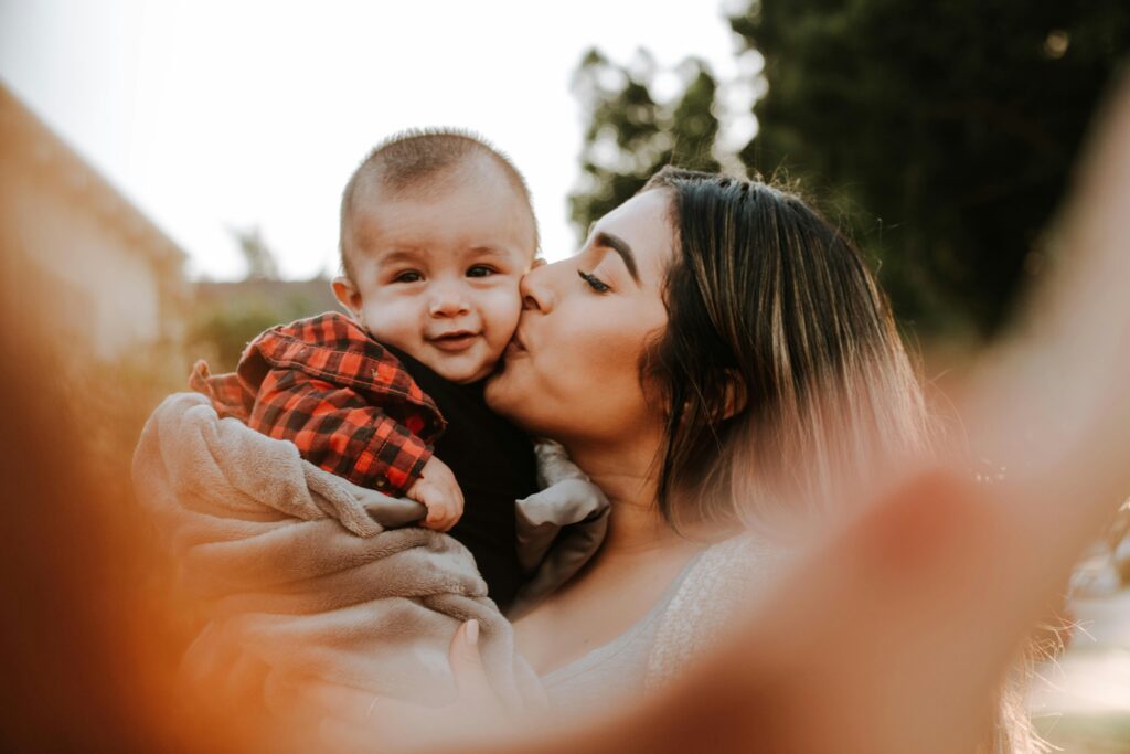 Image of a woman kissing toddler boy. This is to go with an article discussing when to make a relationship serious if children are in the mix.