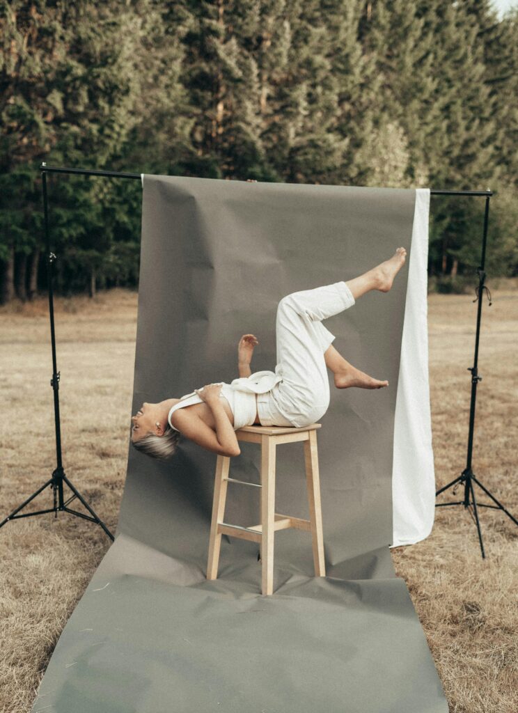 Woman wearing white laid on a stool.