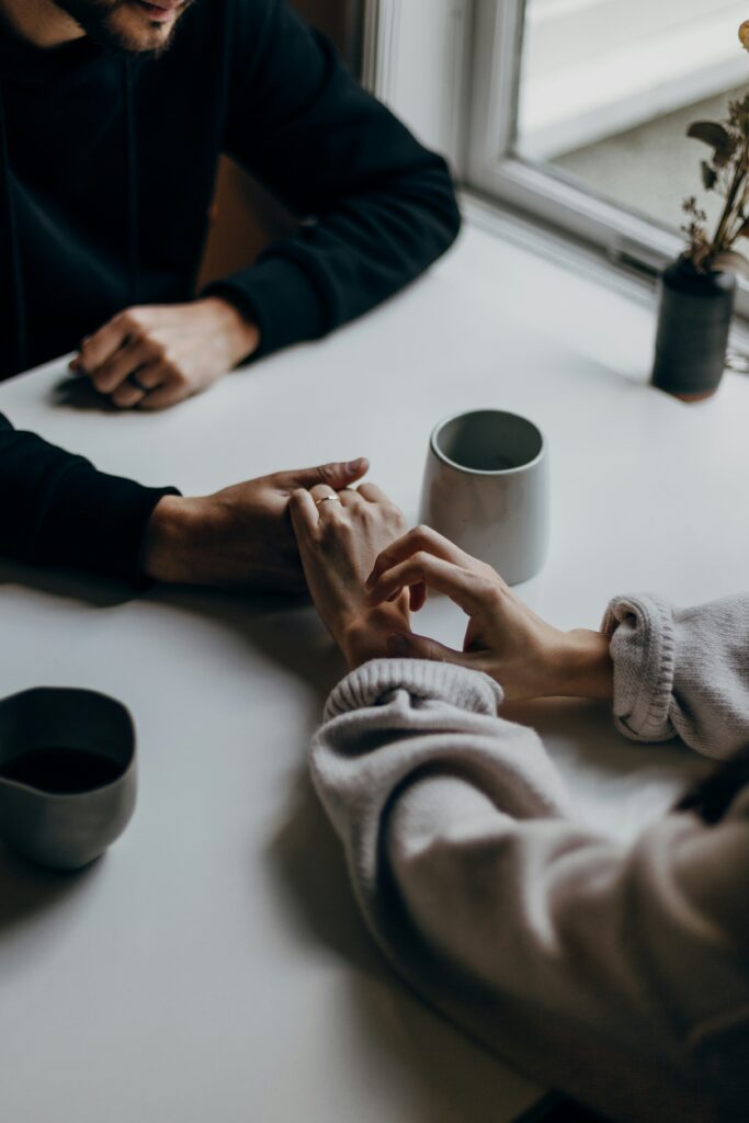 Image of a couple holding hands across a table.