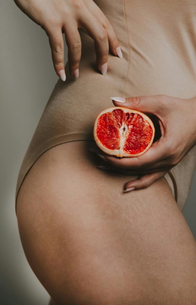 Side image of a woman holding red orange.