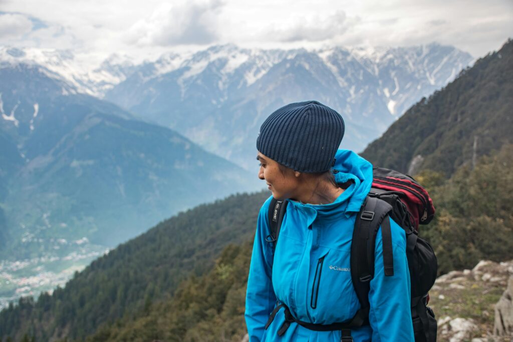 Woman wearing hiking gear up a mountain. This is to go with an article giving 10 hiking essentials.