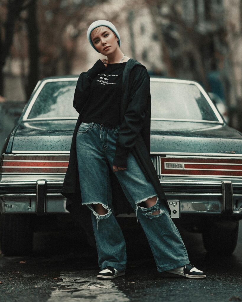 Alternative looking woman stood in front of first car.