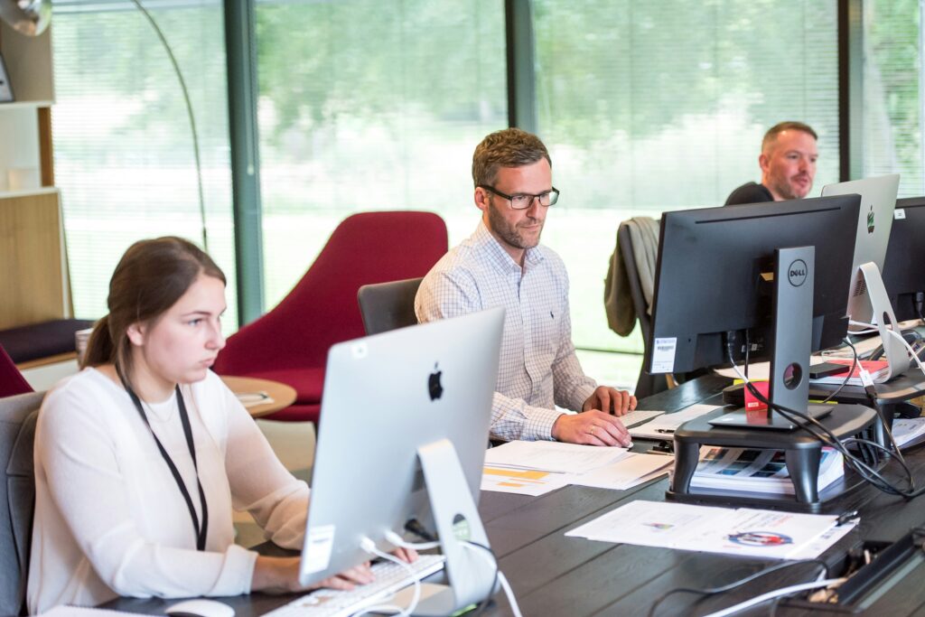 Three people working in an office. This discusses how to optimise your time as a business owner.