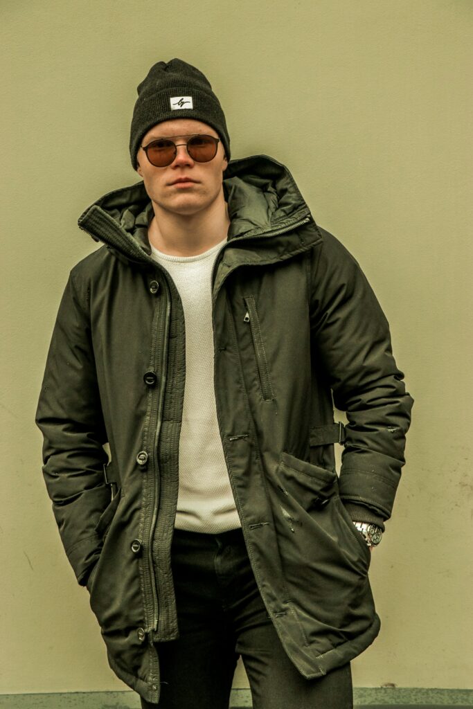 Man wearing an open jacket and beanie.