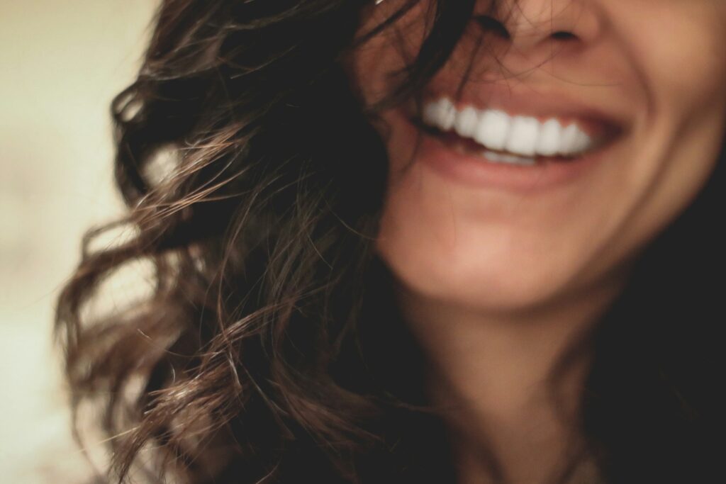 Woman with veneers, smiling.